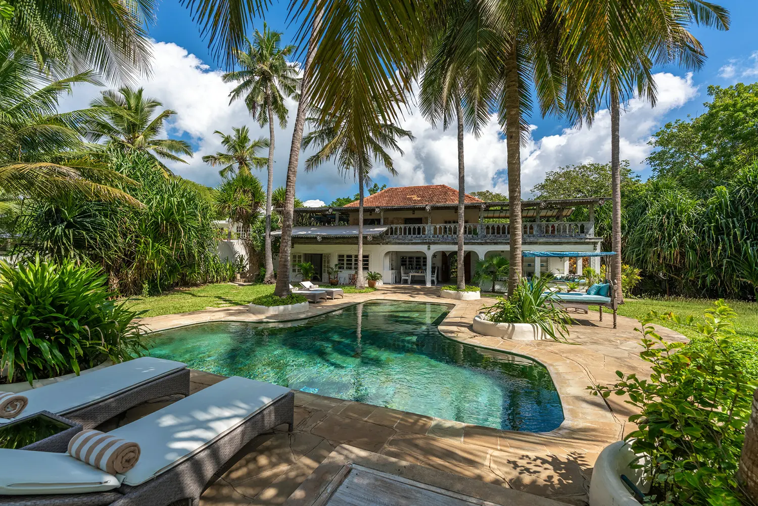 Beachfront villa with pool and palm trees